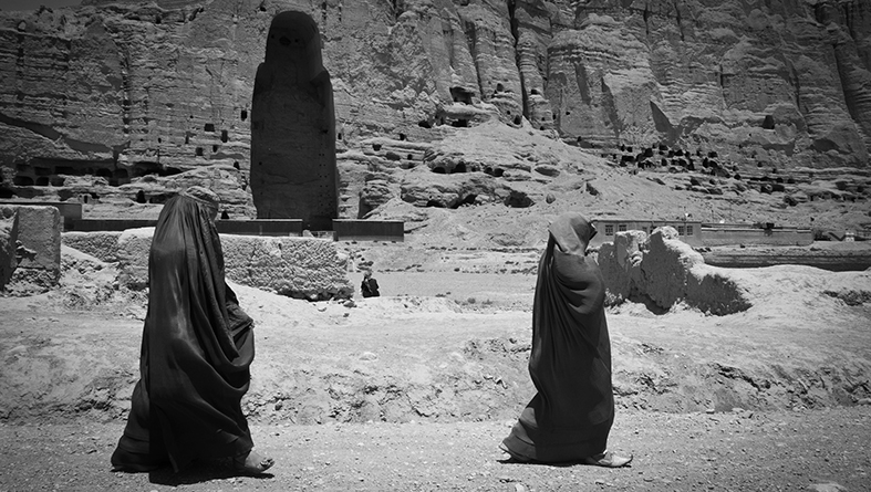 BAMYAN PROVINCE, Afghanistan - Two women walk past the huge cavity where one of the ancient Buddhas of Bamiyan, known to locals as the 